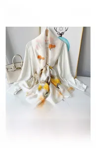 Detail of silk satin scarf with autumn orange tree pattern on a white shirt
