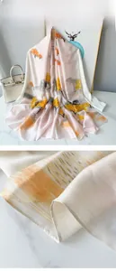 Detailed close-up of landscape print silk scarf with light-reflecting satin texture