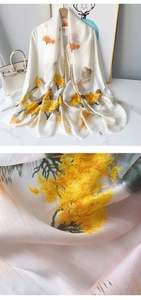 Detailed close-up of silky satin scarf texture with elegant landscape print and size tag