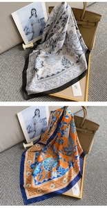 Close-up of vintage floral print silk scarves in orange and blue with elegant hemmed edges