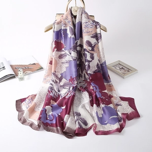 Elegant floral silk scarf with oil painting patterns hanging on a wooden hanger