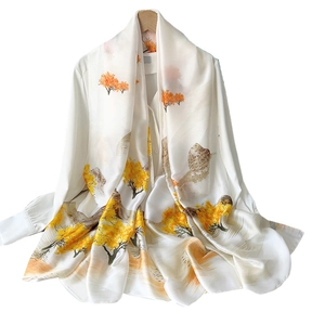 Elegant silk-satin scarf with yellow autumn tree prints displayed on a white shirt