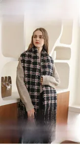 Dettaglio di morbida sciarpa scozzese in finto cashmere con nappe e trama calda e soffice