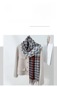 Close-up of houndstooth scarf texture in light blue and beige with tassel detail