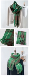 Detailed view of green and brown plaid scarf featuring soft fringe and cashmere-like texture