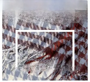 Close-up detail of soft houndstooth fabric texture with fringe edges for winter scarf
