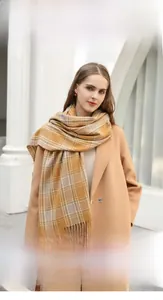 Close-up of yellow plaid imitation cashmere scarf with long fringe details and soft texture