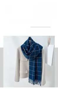 Detail of blue plaid cashmere-like scarf showing soft texture and classic fringe edges