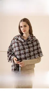 Detail shot of a soft imitation cashmere scarf with classic plaid patterns and tassel edges