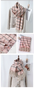 Dettaglio della sciarpa in cashmere a quadri rosa e grigi con eleganti frange lunghe su cappotto