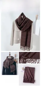 Detail of dark coffee plaid scarf with orange stripes and long tassel fringe texture
