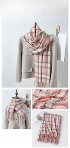 Detailed view of soft pink and white plaid scarf featuring elegant tassel fringe trim