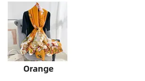 Detailed view of orange floral silk scarf draped on a mannequin in a cozy home setting