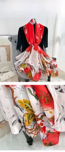 Detail of silk satin scarf with red and white floral prints and glossy texture