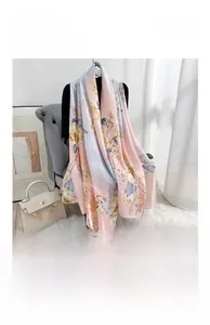 Detailed close-up of floral print silk scarf with pastel gradient and smooth texture