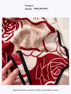 Detailed macro view of red rose floral print on soft velvet-like fabric with black piping