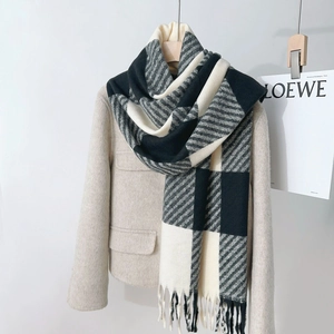 Classic plaid thick cashmere scarf with tassels shown over a beige wool coat