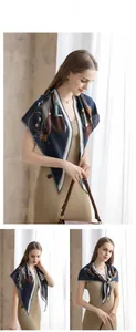 Detail of navy blue oversized square scarf with vintage carriage print and chevron border