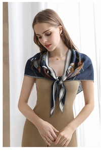 Detail of elegant printed silk scarf in navy blue and gold tied around the model's neck