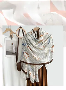 Detail of floral pattern scarf with vintage monogram and brown rolled edges