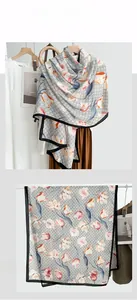 Detail view of floral print scarf featuring orange tulips and luxury interlocking patterns