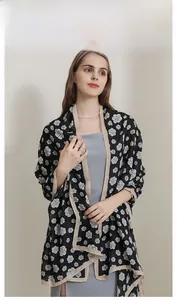 Detail of camellia print scarf with black and white pattern and beige contrast hem edge
