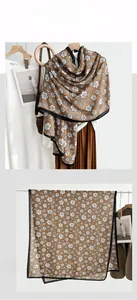 Detail of camellia flower print on brown scarf with elegant black stitched edges