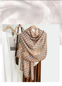 Detail of cotton linen scarf with checkered pattern and orange floral print on a hanger