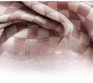 Macro shot of red and beige checkered cotton linen fabric showing soft texture and weave