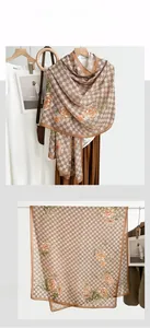 Detail view of cotton linen scarf featuring beige checkerboard and orange floral patterns