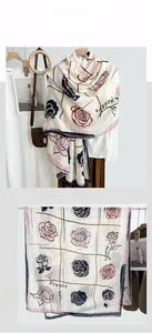 Detailed flat lay of a floral scarf with camellia print and France lettering motifs