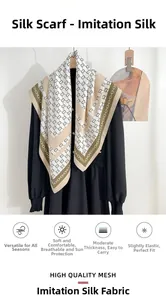Detail of elegant chain and monogram print silk-like scarf on a black dress