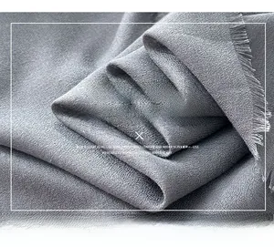Detailed macro view of the grey fine-woven fabric texture with fringe edges for women