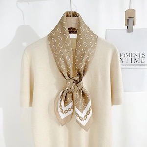Elegant silk scarf with geometric chain prints on a beige knit top hanger display