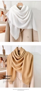 Detailed view of white and camel mercerized wool scarves with delicate fringe edges