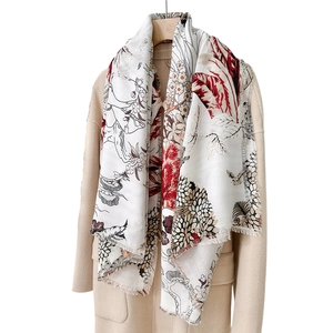 Élégante écharpe beige à imprimé floral vintage avec franges sur un manteau