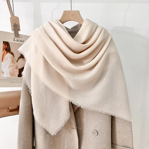Elegant beige solid color scarf shawl with short fringe on khaki wool coat