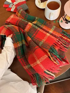 Detail eines rot-grünen Karo-Schals mit langen Fransen und passenden Strickhandschuhen