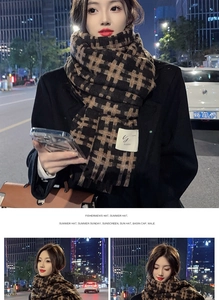 Close-up of classic brown and black plaid scarf with decorative stitched letter label