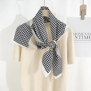 Elegant floral and houndstooth pattern faux silk square scarf tied on a beige knit top