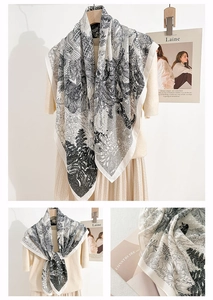 Detail of elegant black tropical plant print on a soft white faux silk square scarf