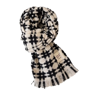 Classic black and white checkered knit scarf with soft fringe edges and a woven label
