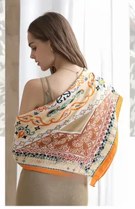 Detail of 90cm bohemian silk scarf featuring orange herringbone and ethnic paisley patterns