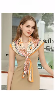 Detail of bohemian printed square scarf with elegant floral brooch on a fashion model