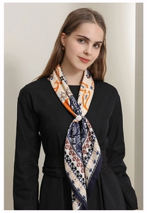 Close-up of bohemian silk scarf with paisley pattern and golden flower ring clip