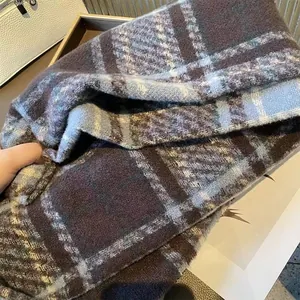 Close-up of thick plaid winter scarf texture showing warm brushed fabric details