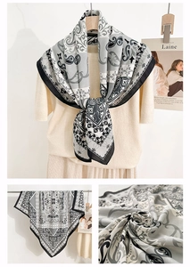 Detail of bohemian retro printed silk scarf showing paisley pattern on beige sweater