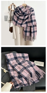 Macro view of plaid cashmere-like scarf showing soft texture and blue-pink tassels