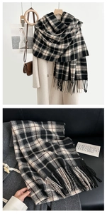 Detail shot of black and white plaid scarf with soft tassels and premium cashmere texture