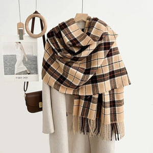 Elegant plaid scarf with tassels in earth tones over a long coat for autumn and winter style
